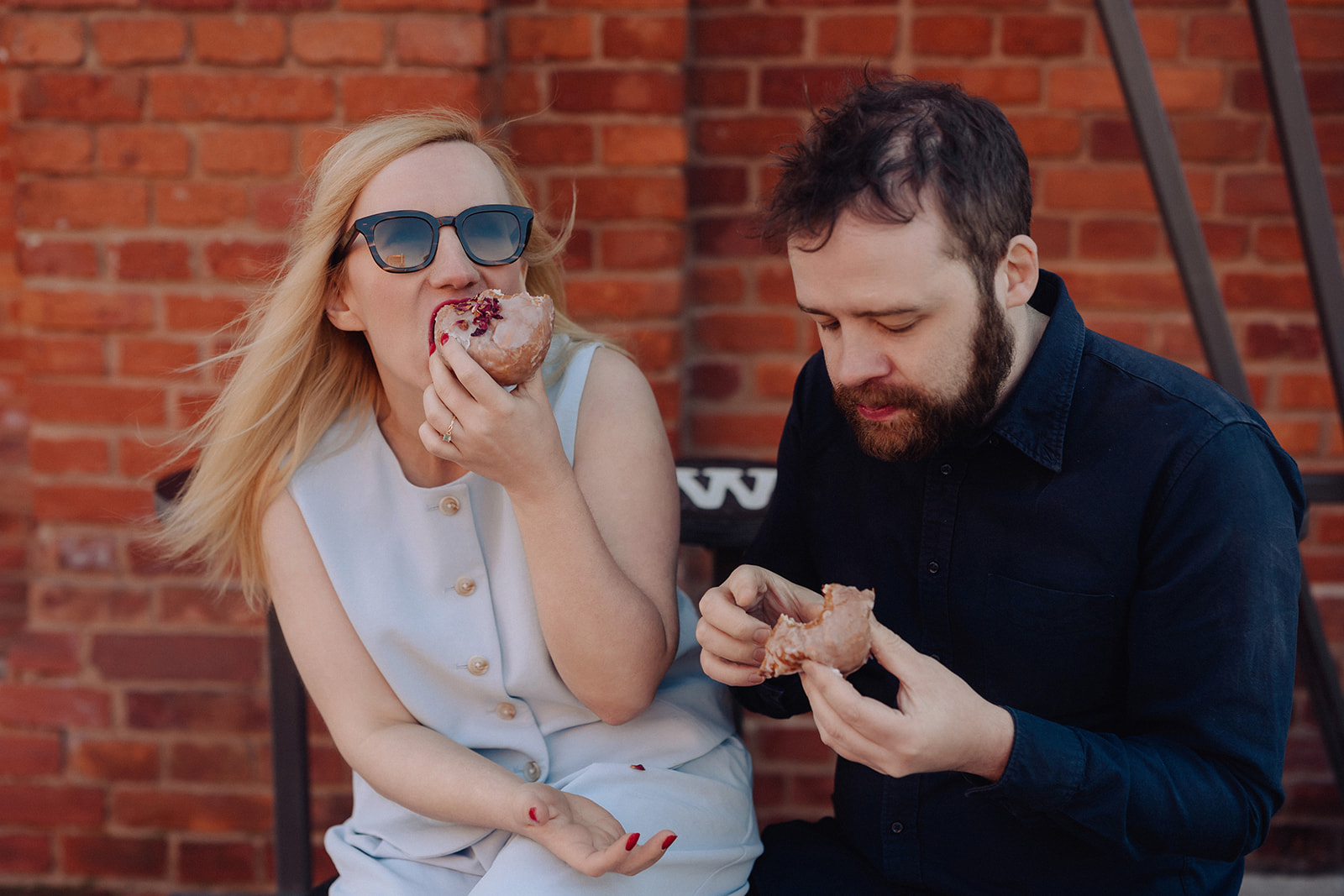 Nat and Alex in front of brick building with arched doorways